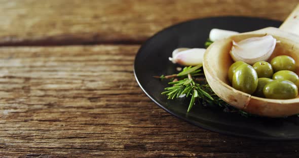 Ingredients olive and garlic kept on a black plate