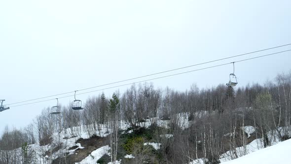 Empty Funicular Cabins Go on the Ropeway Through Fog. Early Morning Trip Above Misty Forest in