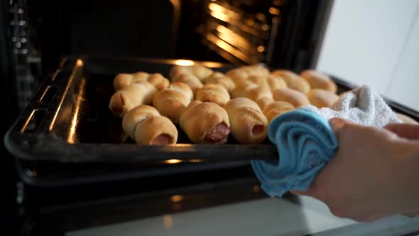 The Woman Takes Out a Baking Sheet with Pastries From the Oven Hot Pies