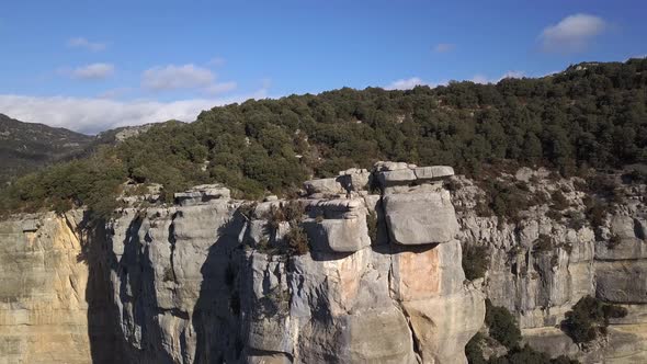 Aerial view of man standing on edge of projecting cliff, zooming out shot