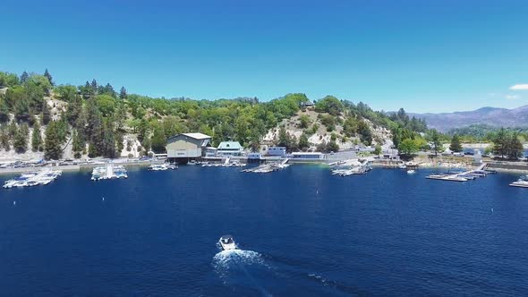 Aerial drone  approaching the boat and the pier near a mountain at Arrowhead Lake, California, USA