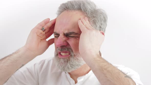 Grayhaired Bearded Caucasian Man Having a Serious Headache and Touching His Temples with Palms to