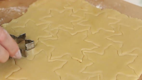 Woman Cuts Cookie Dough. With A Snowflake Shape. Cooking Marshmallow Sandwiches. Close Up Shot.