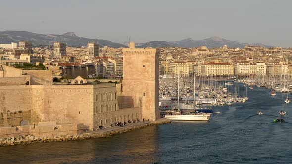 Marseille, France. Boats Sailing By the Old Port of Marseille. A Tower of Fort Saint-Jean Is Seen in