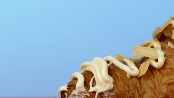 Macro shot of a croissant dessert on a blue background. Close-up, the camera slowly moves