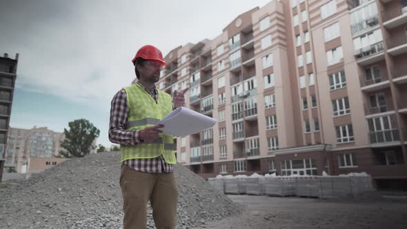 Male Builder Considers Brought Building Material at Construction Site Controls Materials