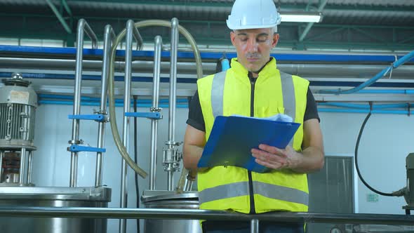 caucasian male senior engineering wearing safty uniform hand use laptop quailty control