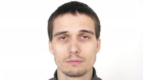 Portrait of Young Attractive Upset Man Looking at the Camera on a White Background