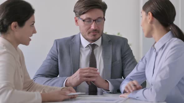 Male and Female Business People having Conversation in Office