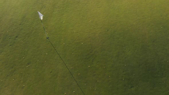 Moving over a golf course with a white flag.