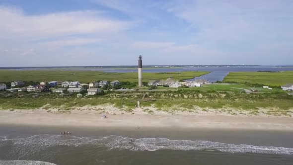 Drone flying towards lighthouse over the ocean