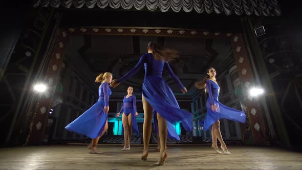 Group Young Skillful Ballerinas Dancing Modern Ballet on the Stage of Large Hall. Girls Looking at