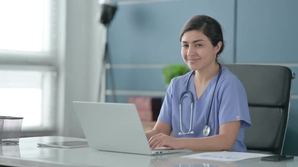 Indian Female Doctor with Laptop Shaking Head as Yes Sign