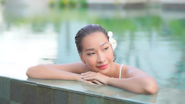 Young asian woman enjoy around outdoor swimming pool for leisure