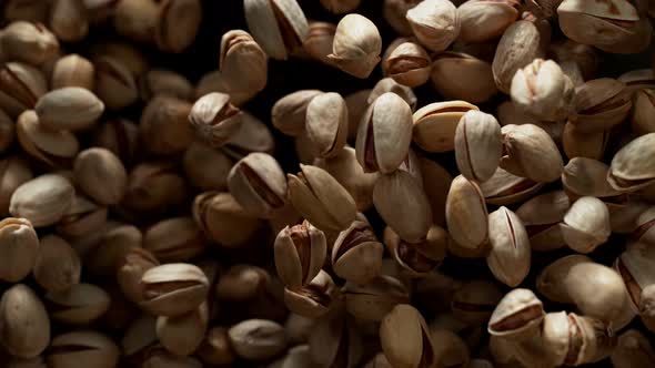 Super Slow Motion Shot of Pistachios Flies After Being Exploded Against Black Background 1000Fps