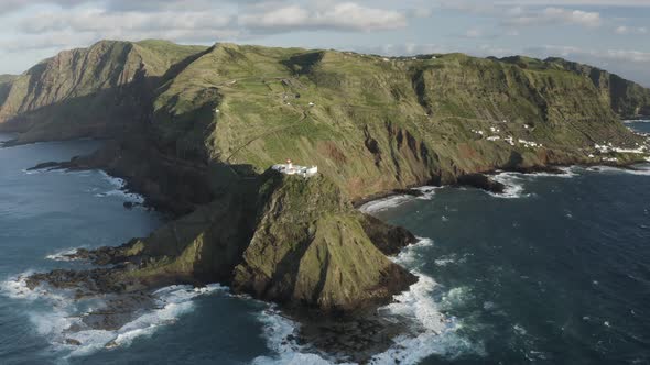Aerial View of lighthouse on the peak of the cliff by the ocean, Santo Espirito. alt