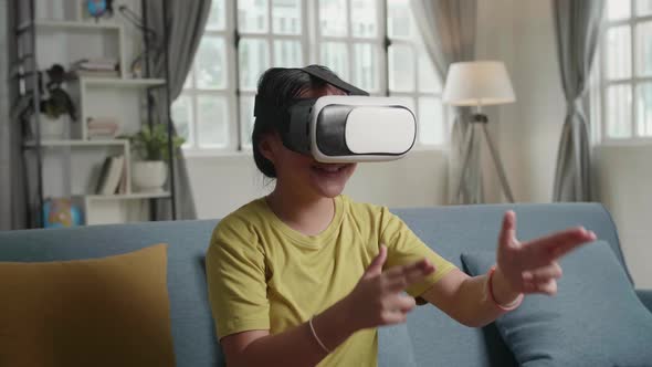 Asian Girl Playing Video Game While Wearing VR Glasses Headset At Home