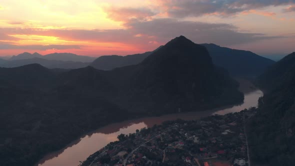 Aerial: flying over Nam Ou River Nong Khiaw Muang Ngoi Laos, sunset dramatic sky