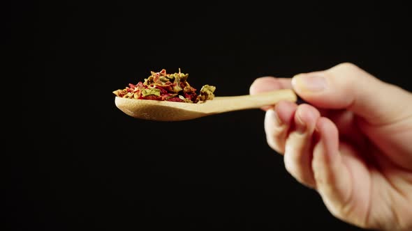 Pouring Spices From Wooden Spoon on Black Background Using Seasoning and Flavors