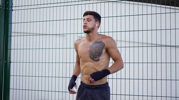 Naked Torso Man Doing Workout in Boxing Bandages