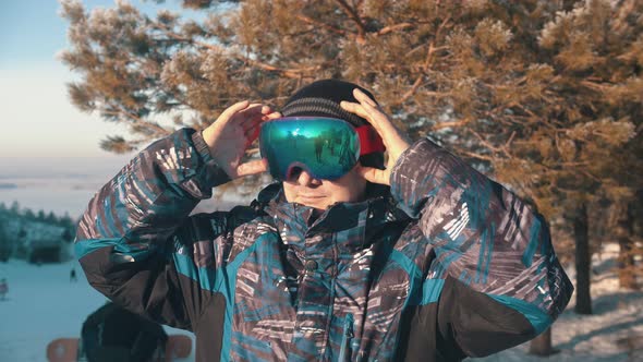 Man Snowboarder Putting on  Glasses