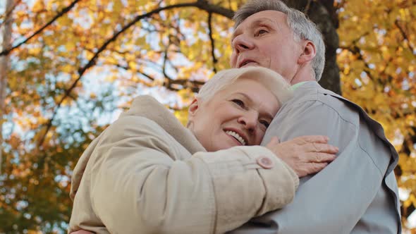 Married Caucasian Elderly Family Middleaged Couple Standing Outdoors in Autumn Park Hugging Gray