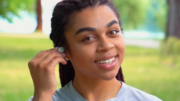 Close Up African Girl Using Earphones in Park