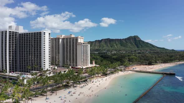 Wide aerial push-in shot of the Diamond Head volcanic formation from Waikiki Beach on the island of