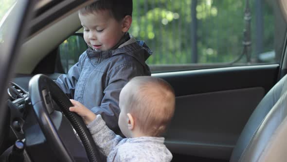 Two Brothers Boys Playing Inside Car Driving Steering Wheel Have Fun Explore