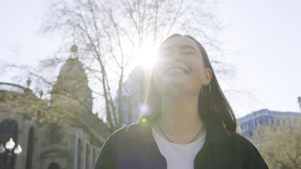 Pretty woman laughing in city on a sunny day