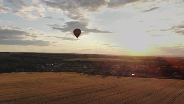 Aerial View: Hot Air Balloon in Sky Over Field in Countryside at Beautiful Sunset