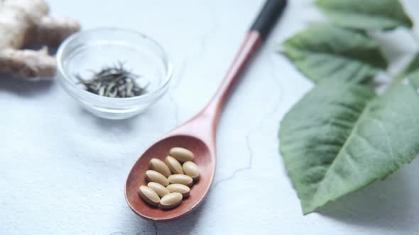 Herbal Medicine on Spoon and Herbs on Table