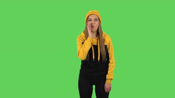 Modern Girl in Yellow Hat Is Screaming Calling Someone. Green Screen
