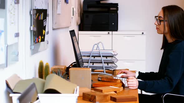 Executive making entry of wooden slab in computer