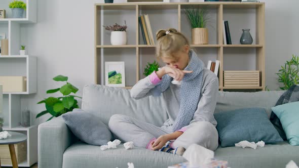 Girl Wipes Her Nose with a Napkin and Looks at the Camera