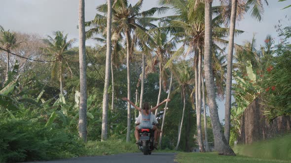 Couple Riding Scooter into Distance