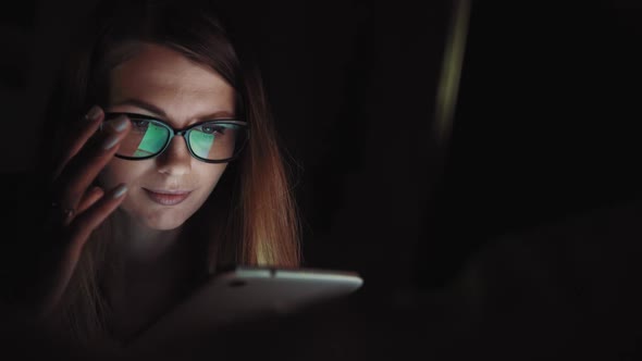 Close Up of Lonely Young Woman Lying on Sofa and Using Smartphone at Night. Depressed Millennial