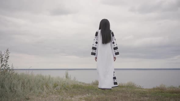 Rear View at Pretty African American Woman Wearing Long Summer Fashion Dress Walking on the Field