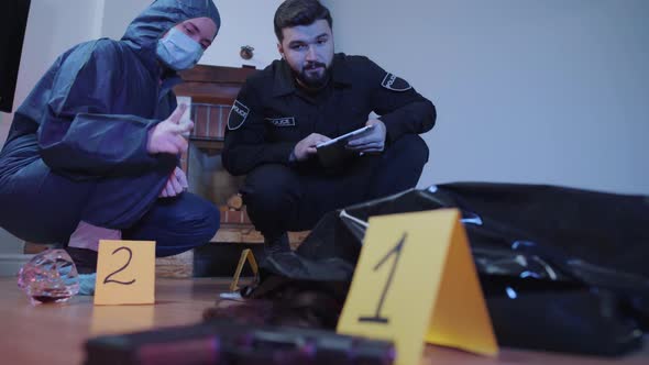 Portrait of Serious Caucasian Police Professionals Discussing Evidence at the Crime Scene. Forensic