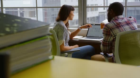 Business workers working over laptop together in modern office