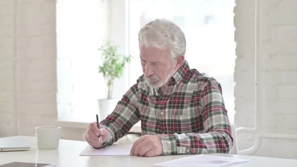 Disappointed Casual Old Man Trying to Write on Paper