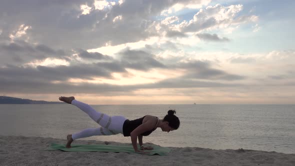 Woman practicing yoga on the beach. Outdoors sports. Healthy living.