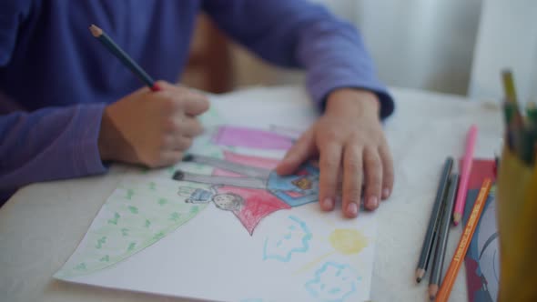 Hands of a drawing child. A child draws his happy family. Close-up of hands