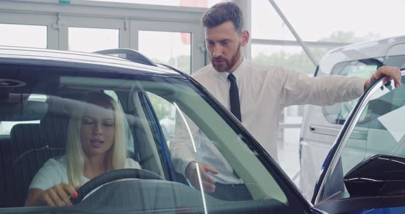 Woman Choosing Car at Salon with Help of Salesman