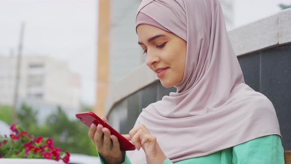 Muslim Woman Texting Outdoors