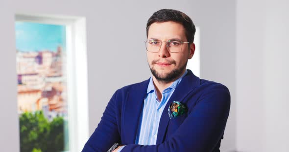 Portrait of Handsome Young Caucasian Male Real Estate Agent in Suit Standing in Empty Apartment