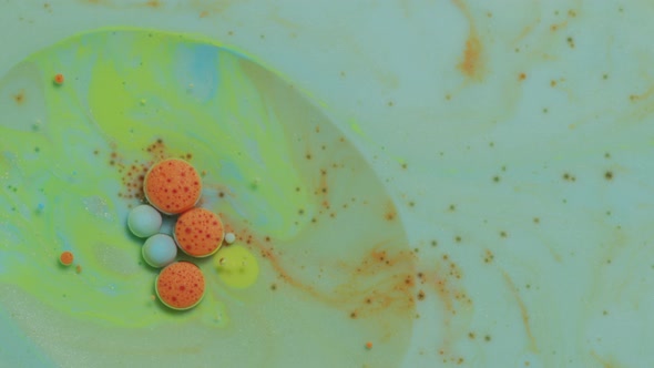 Abstract close up texture of oil with green, orange and blue paint alt