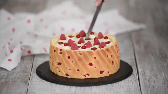 Cutting a Raspberry Mousse French Dessert