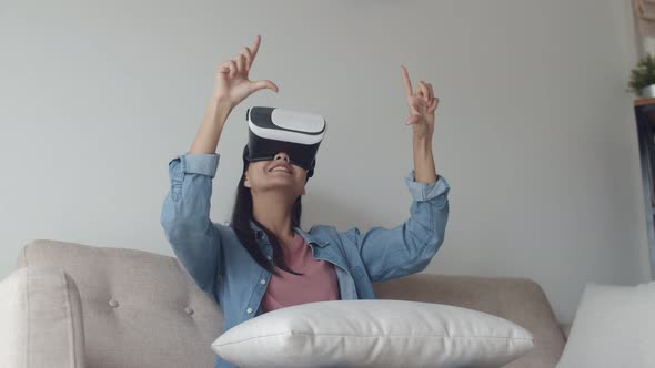 Attractive portrait young Asian woman wearing VR headset in the living room