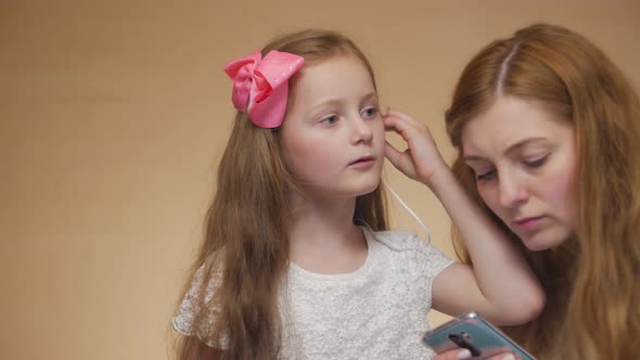 Little Girl Puts On Earphone Portrait